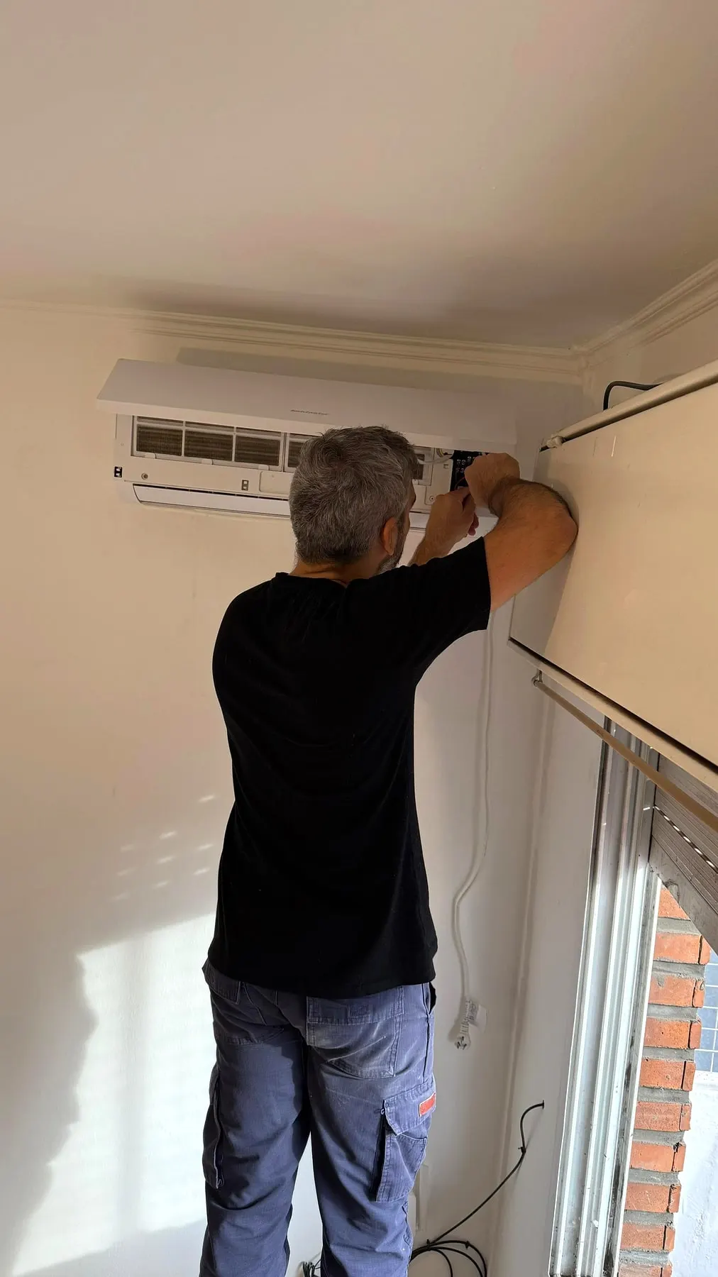 Técnico trabajando en la unidad interior de un split