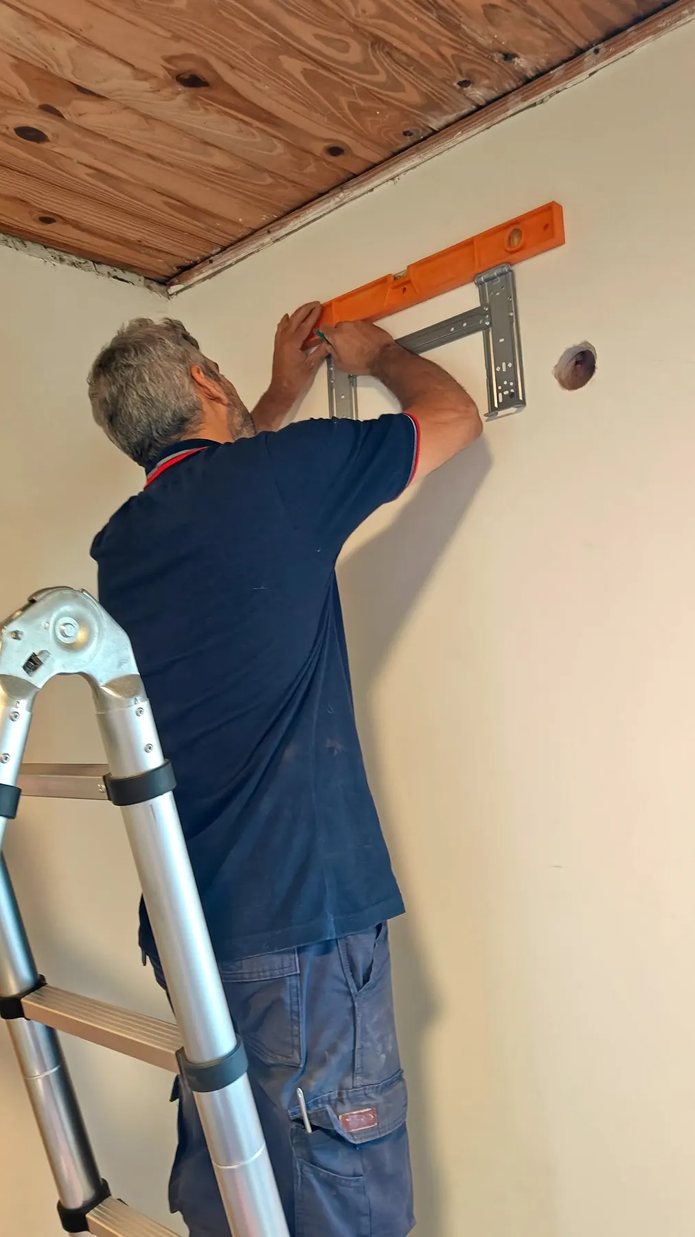 Técnico nivelando el soporte del split antes de colgarlo