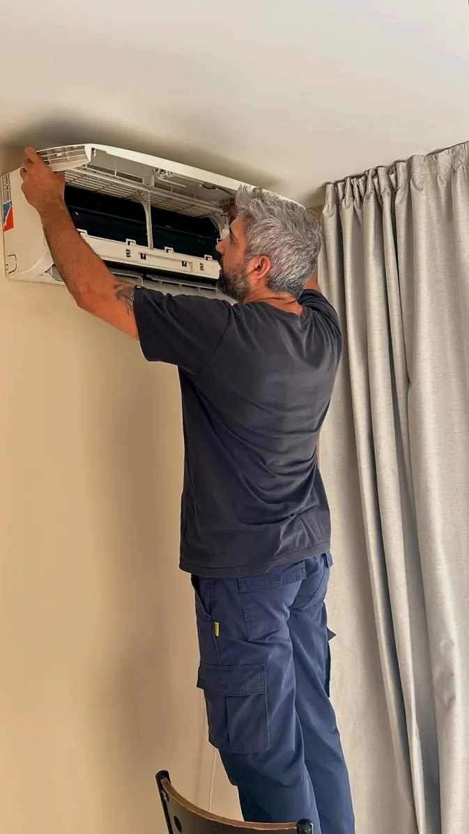 Técnico desmontando la unidad interior para limpiarla